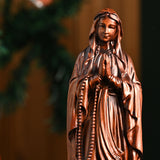 Wooden statue of Our Lady of Lourdes praying